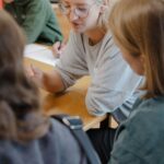 Eine Gruppe von Menschen die an einem Tisch sitzen und sich unterhalten