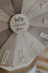 Bild von einem Holz Glücksrad auf dem in der Mitte steht 'Wir kemman zaum'