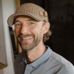 Ein Portrait von Klaus Pointecker mit Mütze am Kopf in einem Innenraum